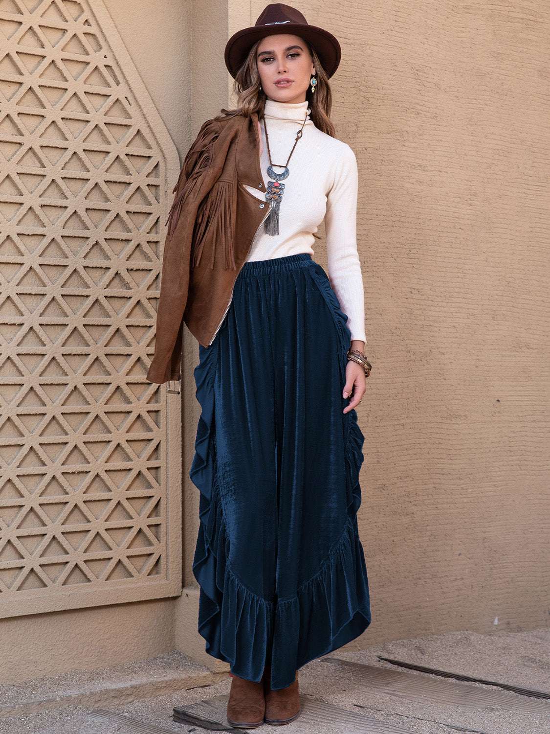 Slit ruffled wide leg pants in dark color, paired with a white turtleneck and brown accessories.