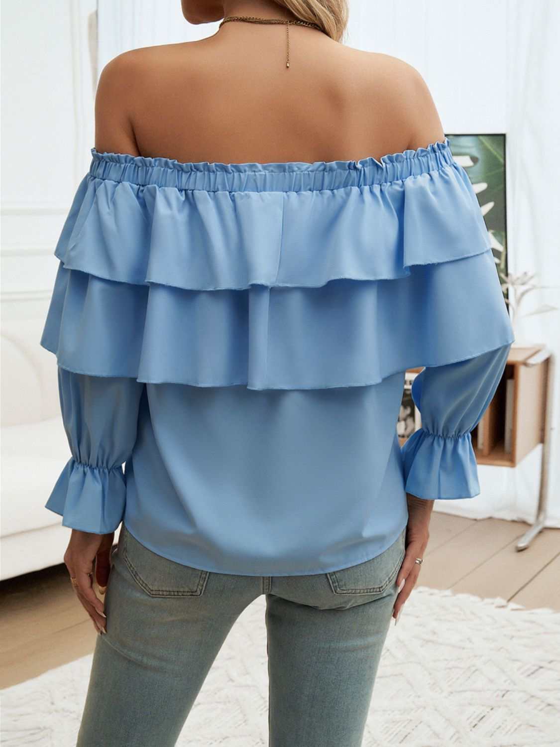 Blue off-shoulder flounce sleeve blouse with ruffled design.