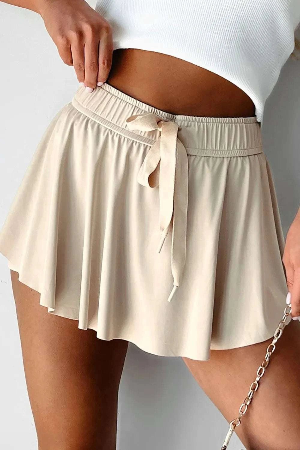 Drawstring high waist lined active skort with moderate stretch in beige.