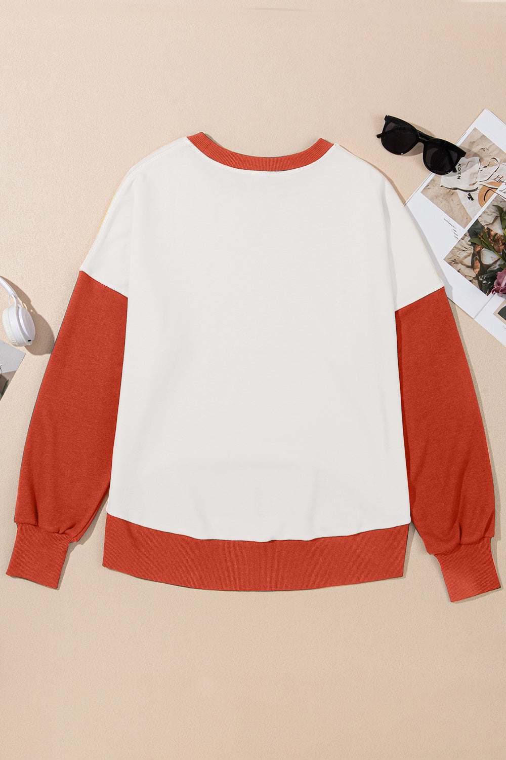 Contrast round neck long sleeve sweatshirt with orange sleeves and trim, made from polyester and cotton.