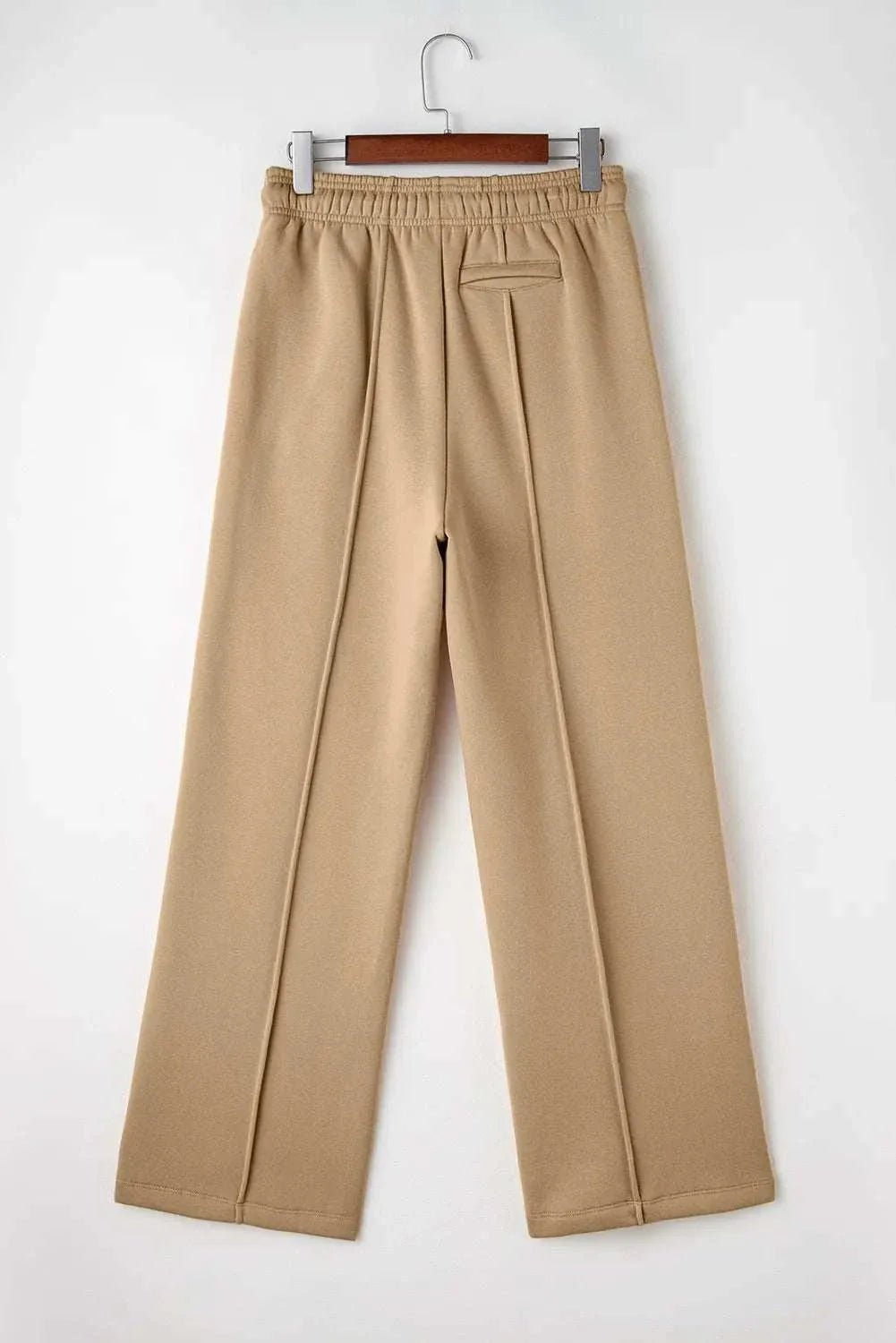 Drawstring wide leg pants with pockets in beige color displayed on hanger.