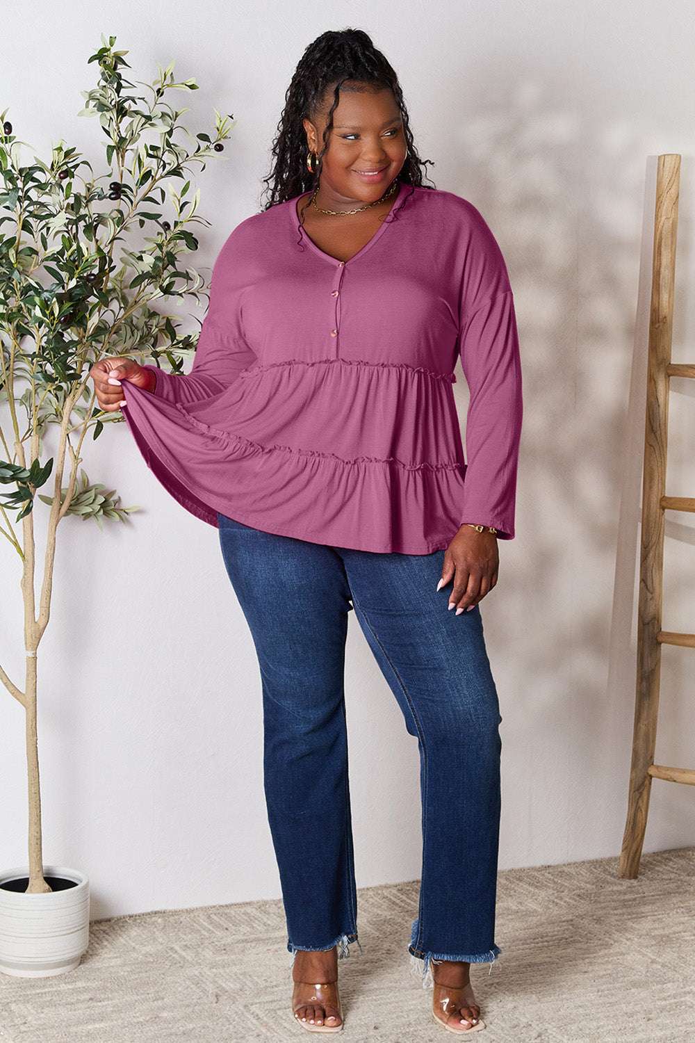 Half button long sleeve blouse with ruffle hem, paired with blue jeans.