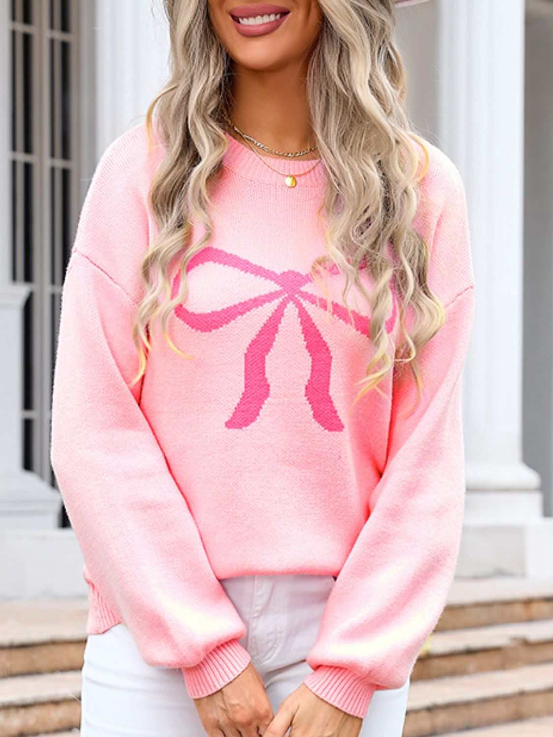 Angel Wings Bow Graphic Round Neck Long Sleeve Sweater in pink worn by a model.