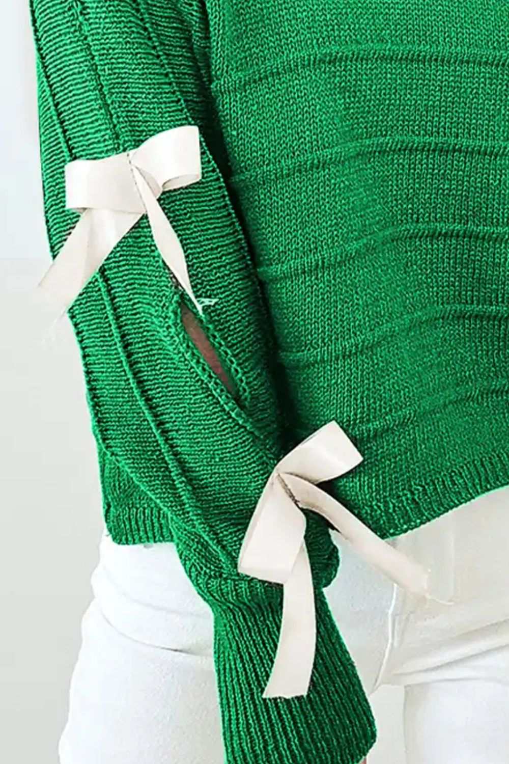 Green bow cutout round neck long sleeve knit top with tied details.