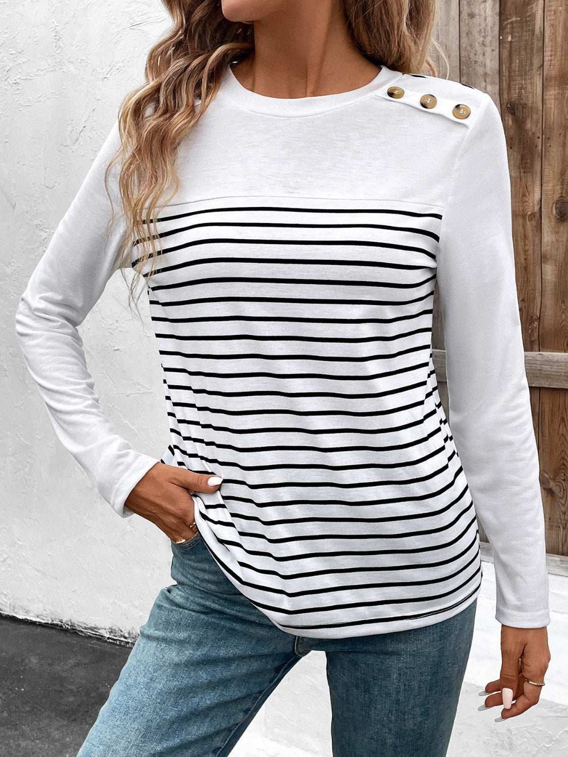 Decorative button striped round neck long sleeve t-shirt with black and white stripes.