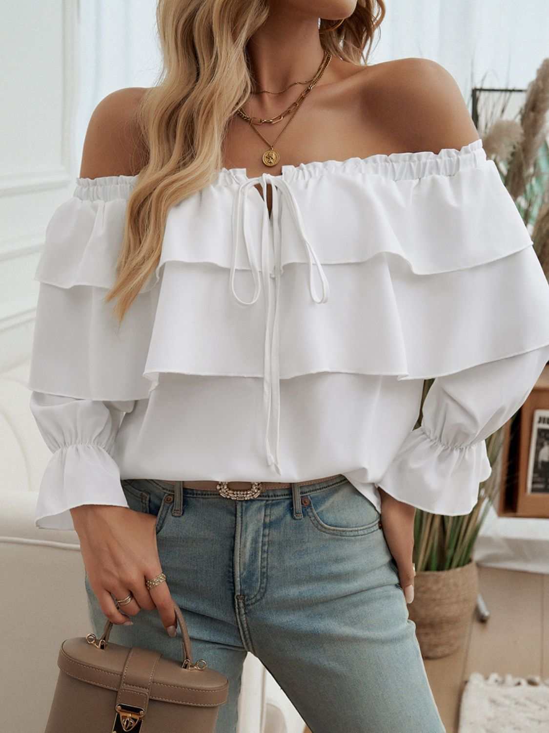 Off-shoulder flounce sleeve blouse with ruffled drawstring design.