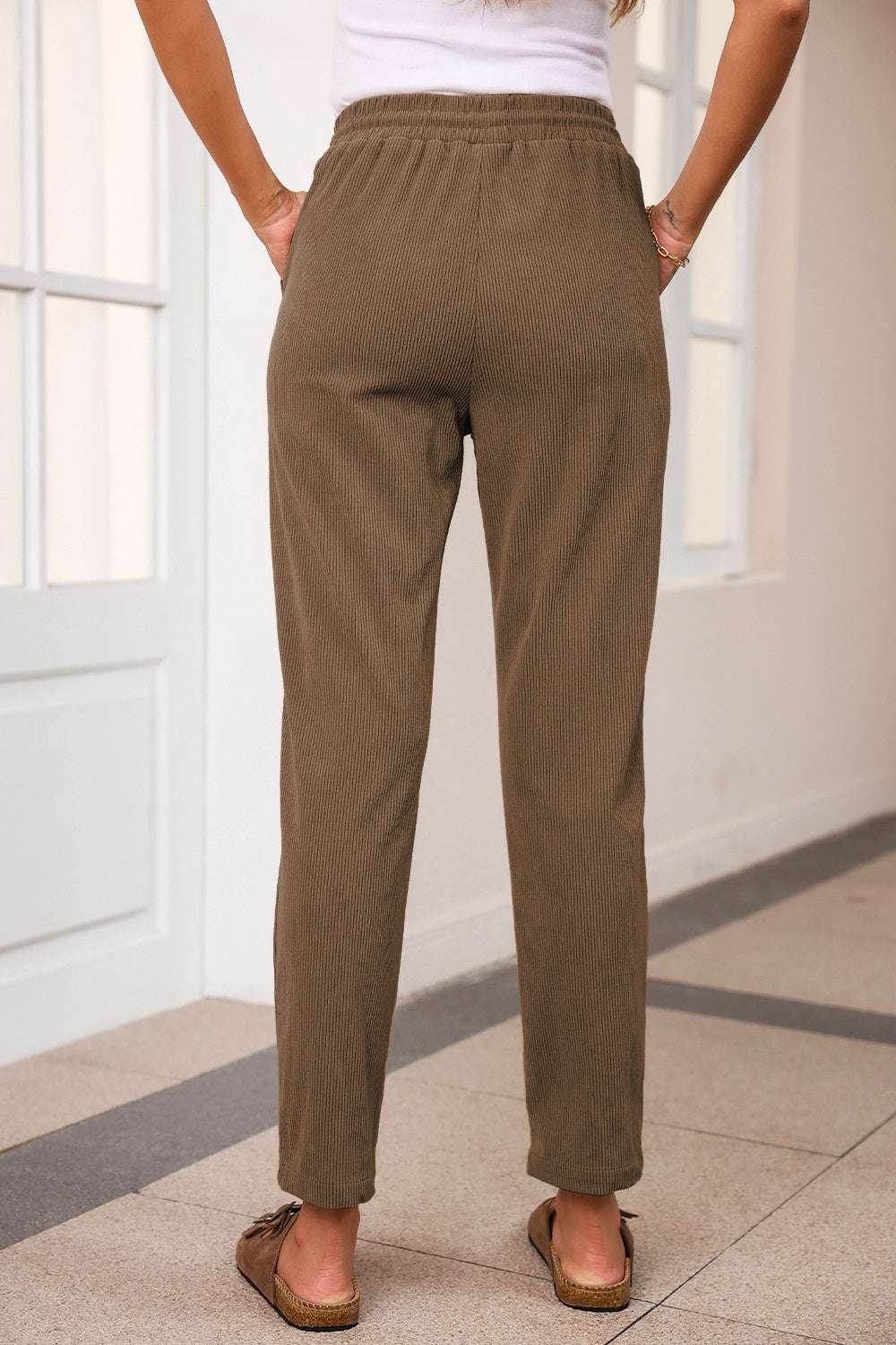 Brown drawstring straight pants with pockets, 100% polyester.