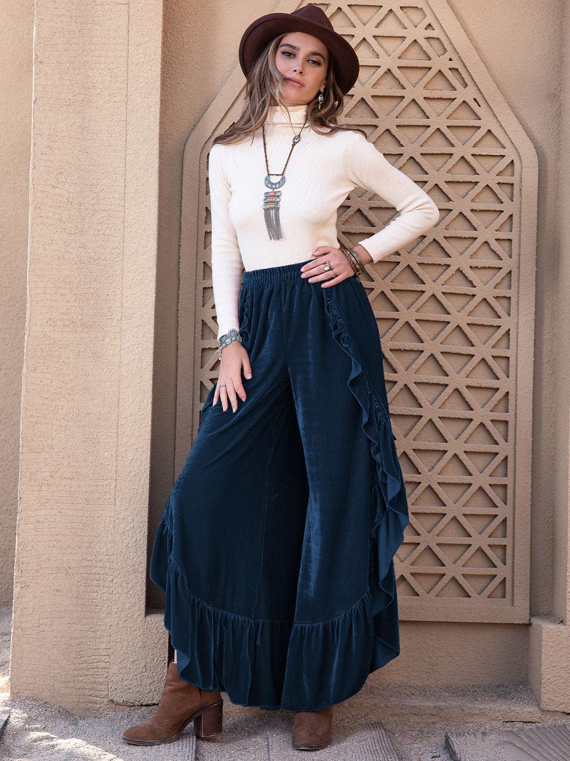 Opaque slit ruffled wide leg pants in dark color styled with a sweater and hat.