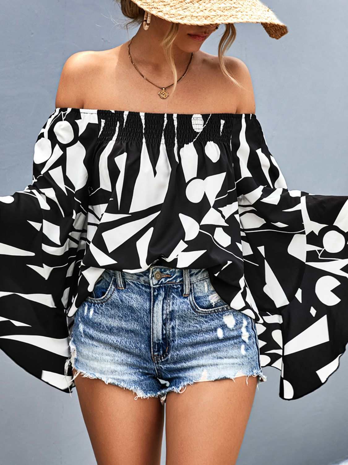 Black and white geometric printed off-shoulder bell sleeve blouse with smocked neckline and three-quarter sleeves