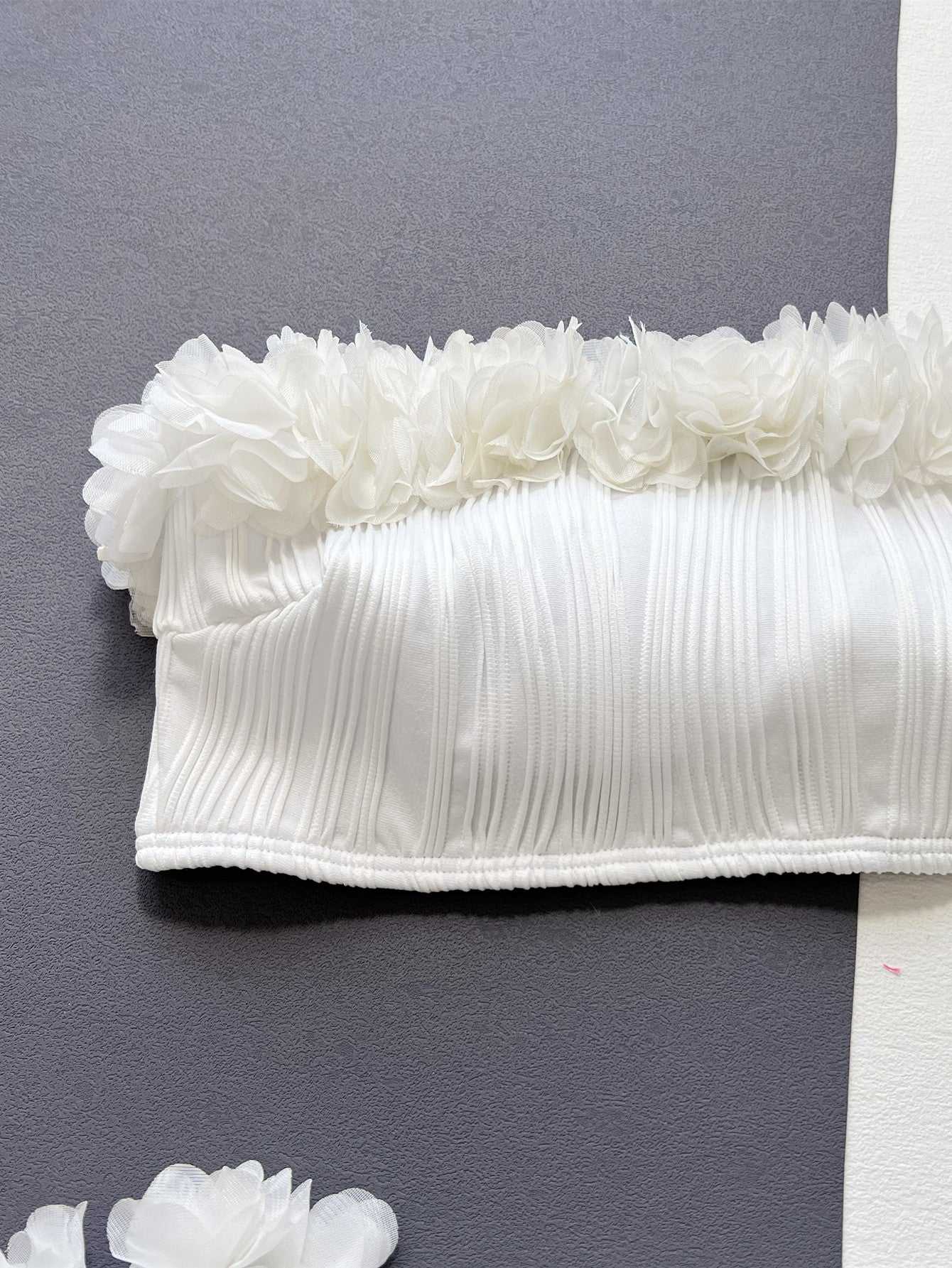 White applique tie back bikini top with floral details and ribbed texture.