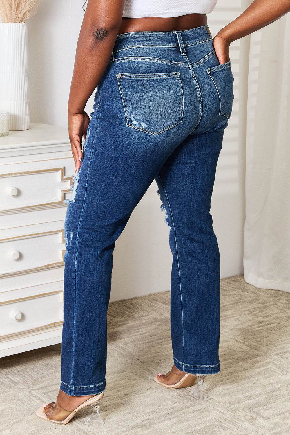 Judy Blue mid-rise bootcut jeans with distressed detailing and hand sanded finish.