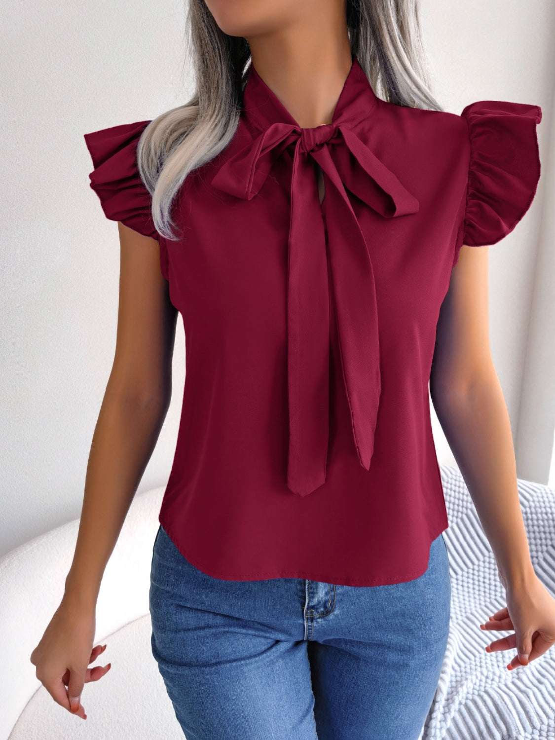 Tie Neck Cap Sleeve Blouse in burgundy with tied feature and slightly stretchy fabric.