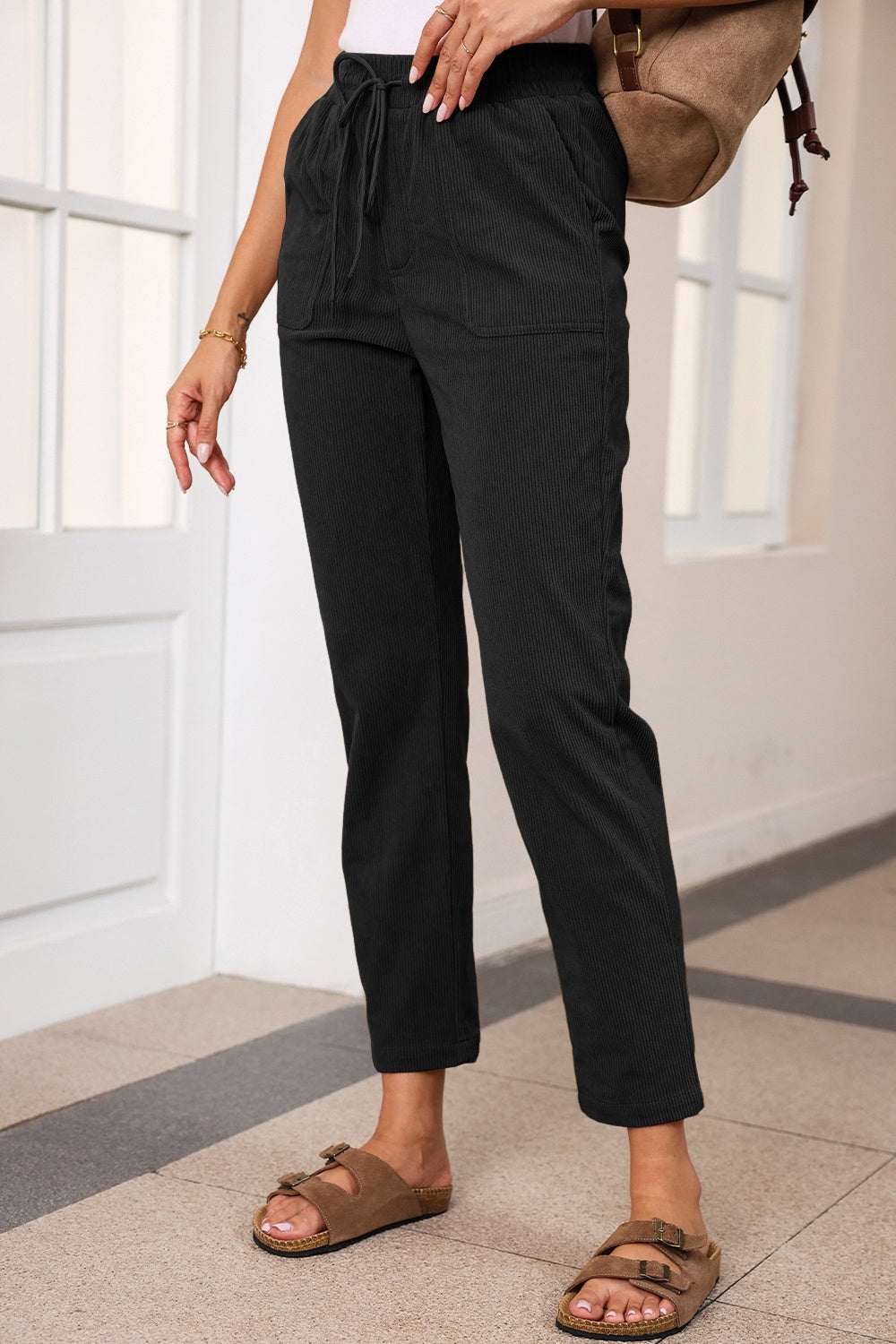 Black drawstring straight pants with pockets, 100% polyester.