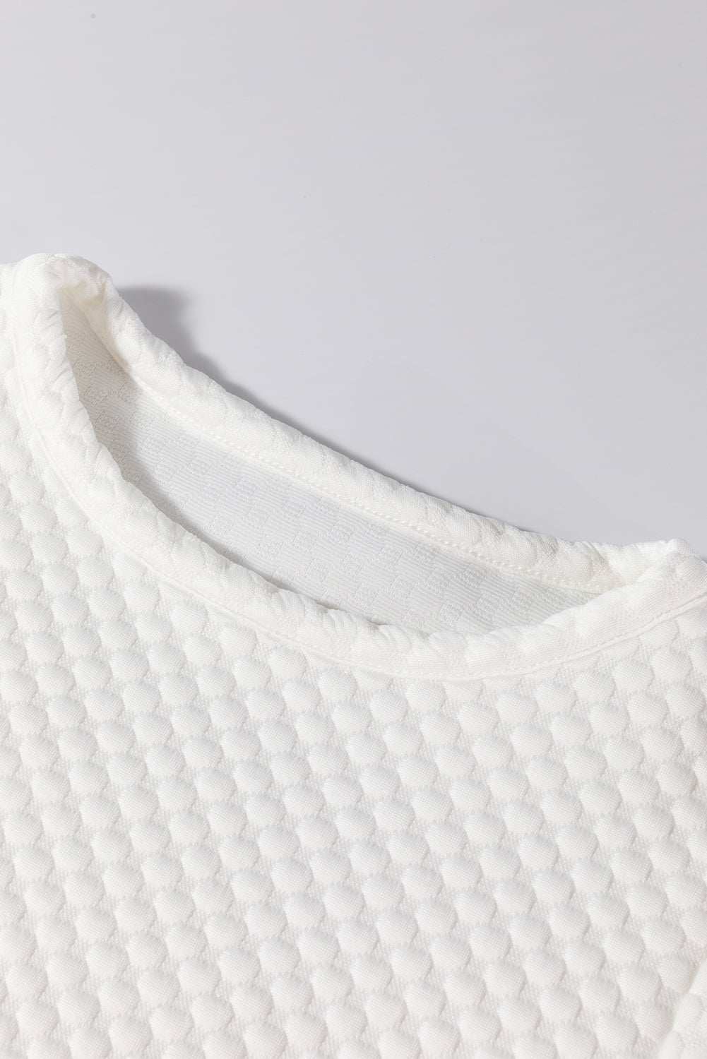 Textured round neck puff sleeve blouse in white fabric.