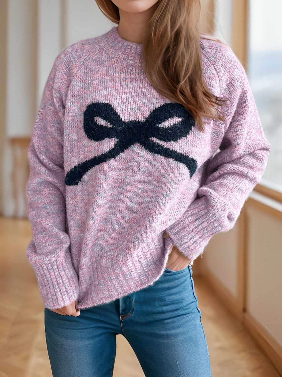 Bow round neck long sleeve sweater in pink with black bow design, slightly stretchy fabric.