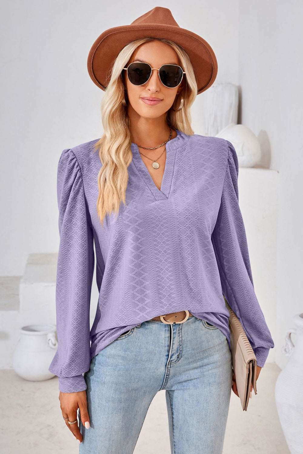 Chic lavender V-neck puff sleeve blouse with long sleeves and notched neckline, paired with jeans and accessories