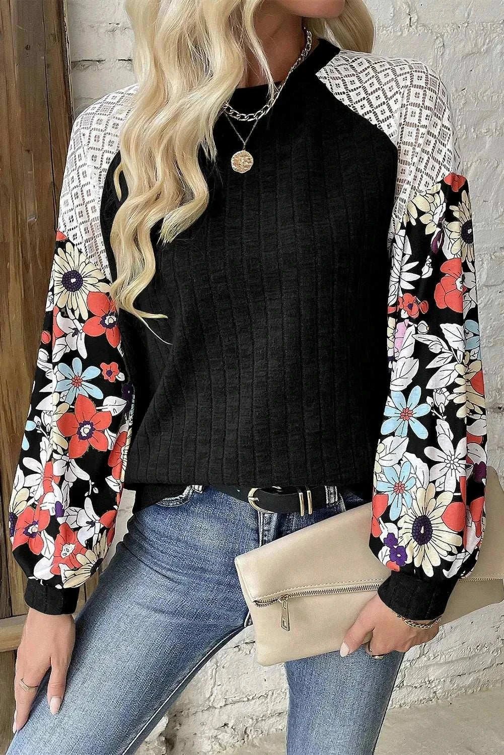 Printed round neck long sleeve top with floral sleeves in black, made of polyester and elastane.