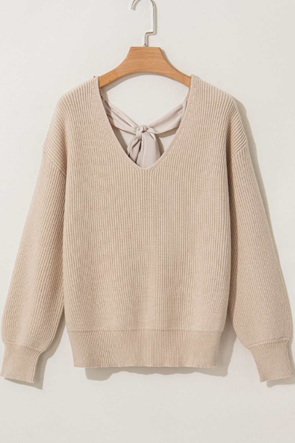 Tied back V-neck long sleeve sweater with bow detail.