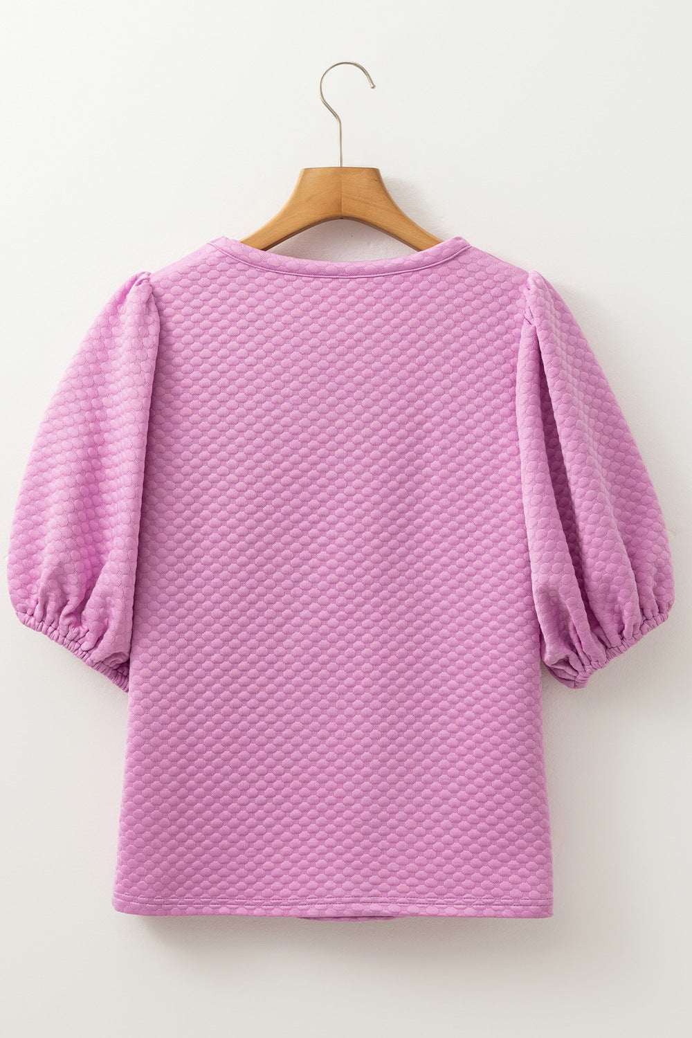 Textured round neck puff sleeve blouse in light purple fabric on hanger.