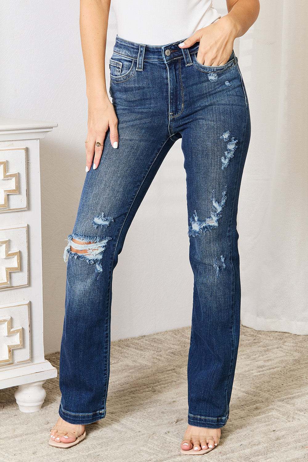 Judy Blue mid-rise distressed bootcut jeans with hand sand detailing.