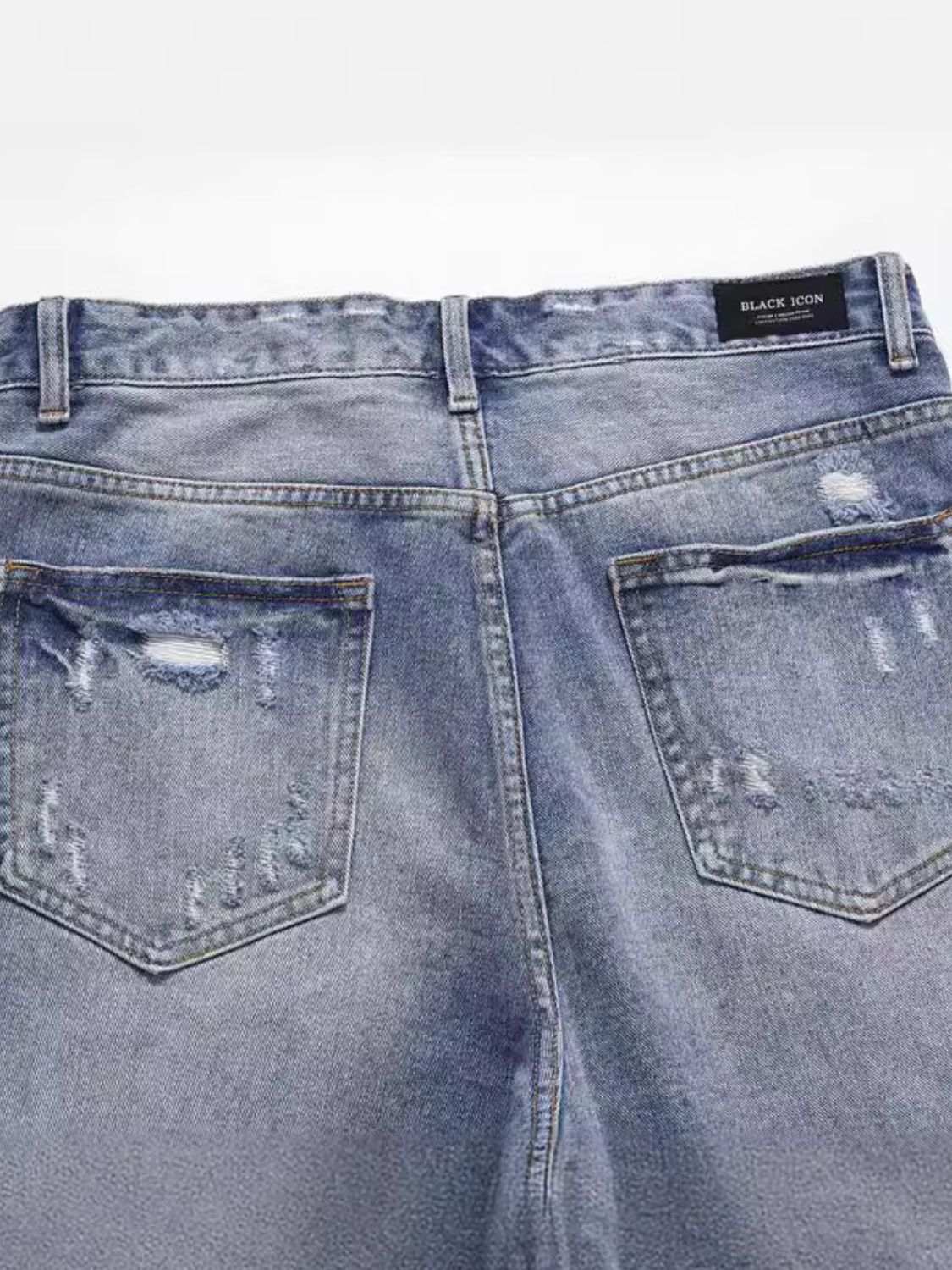 Men's distressed denim Bermuda shorts with slight stretch, back view.