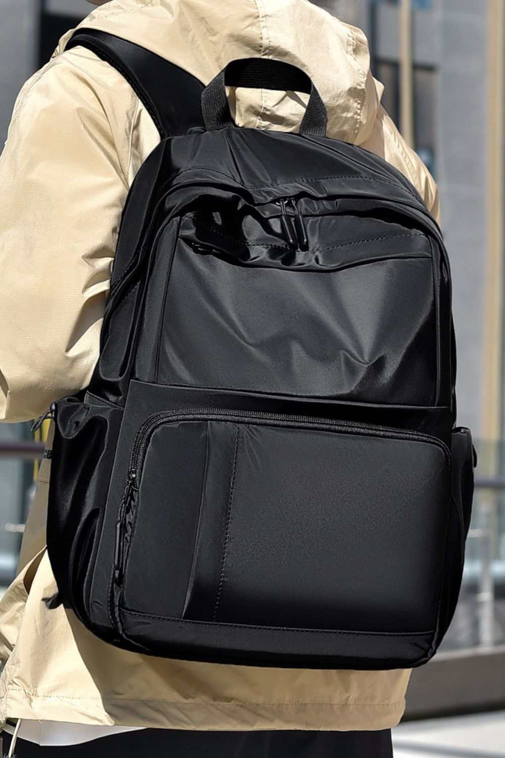 Large solid color multi-pockets backpack in polyester material.