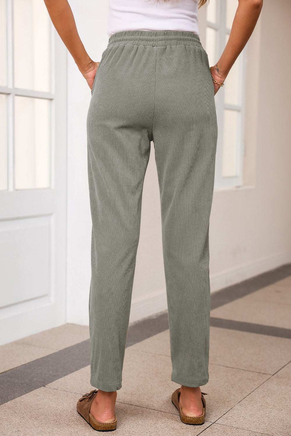Drawstring straight pants with pockets in green color, made from 100% polyester.