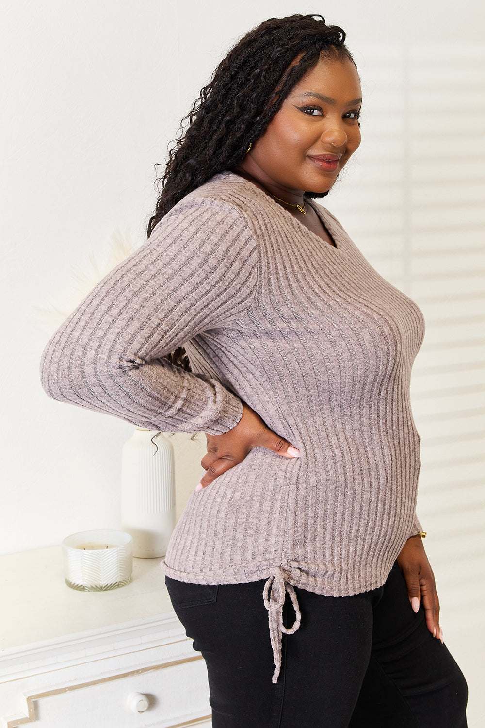 Plus size model wearing a drawstring ribbed long sleeve t-shirt in a neutral color.