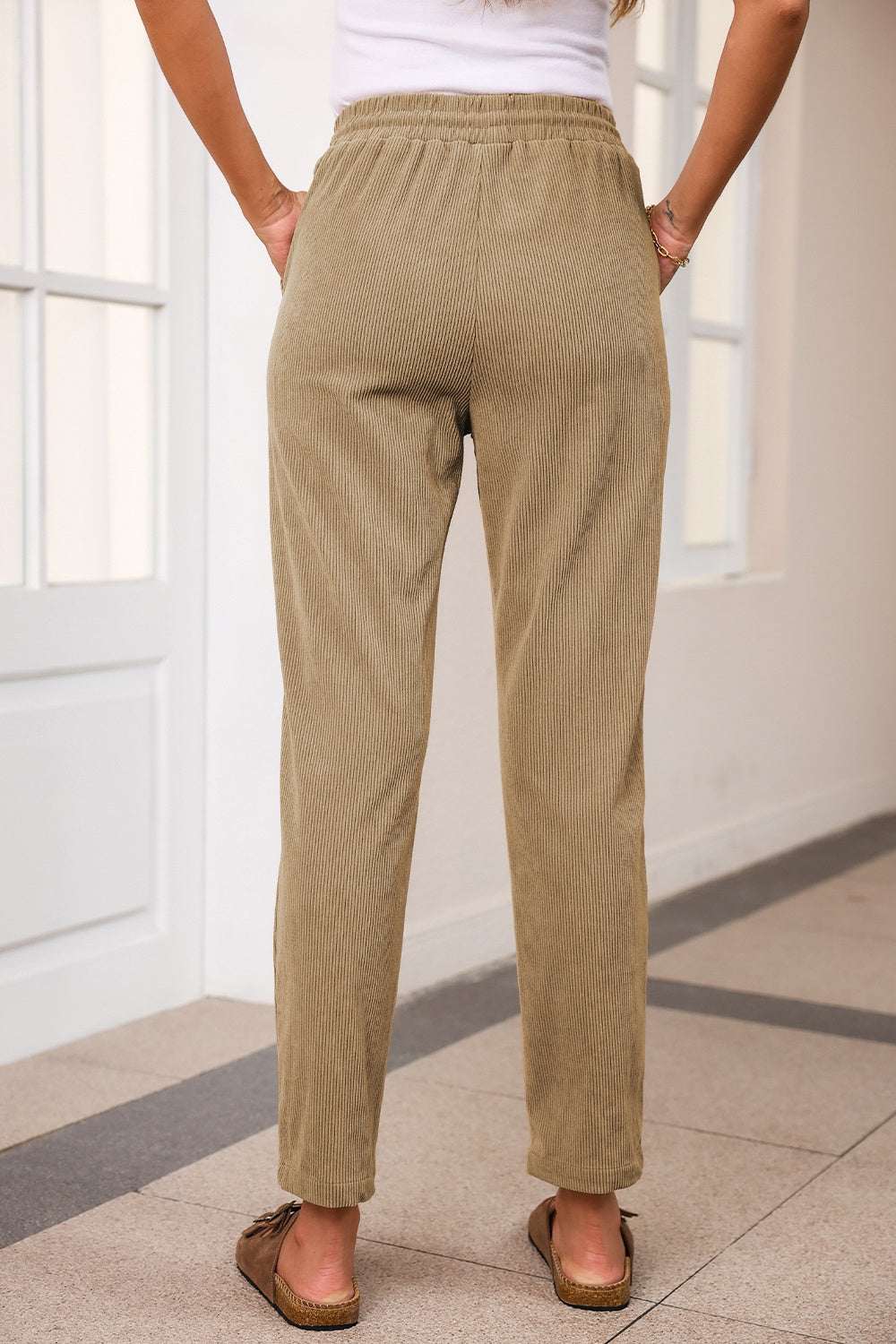 Drawstring straight pants with pockets in beige, 100% polyester, shown from the back.