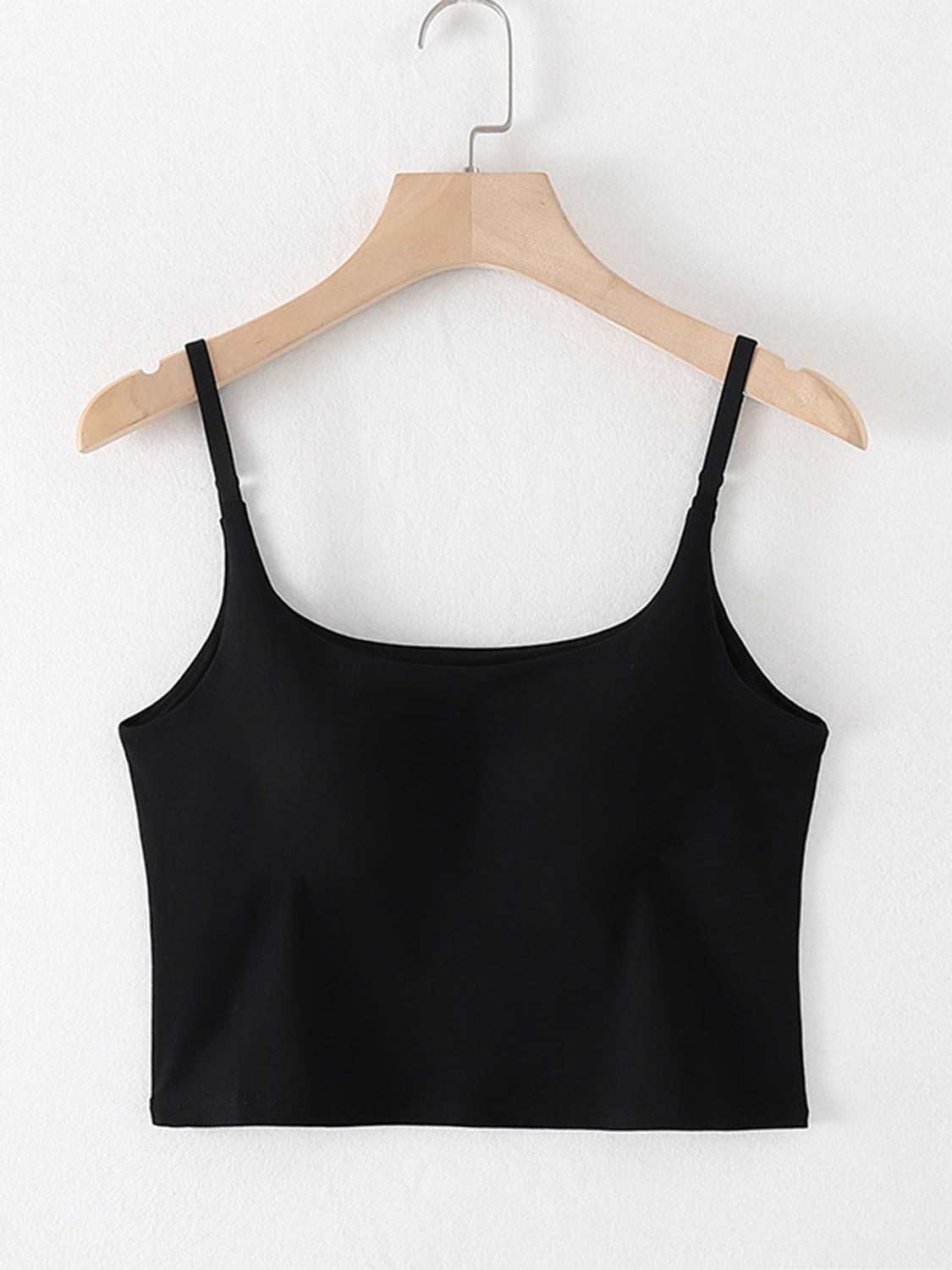 Black scoop neck cropped cami with chest pads on hanger.