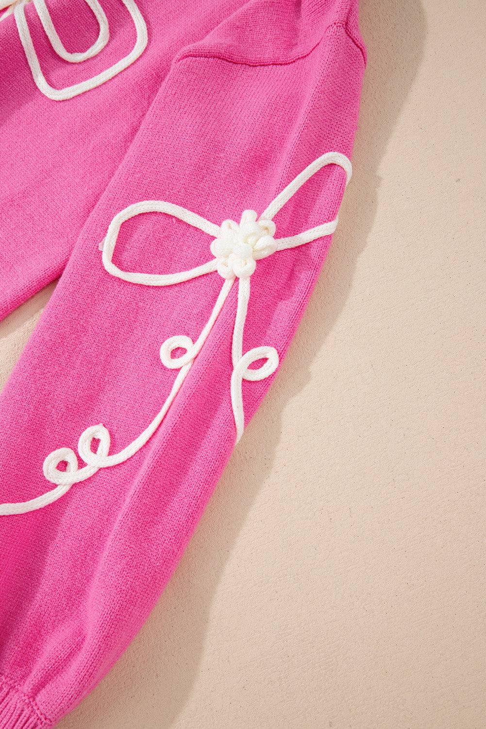 Pink bow round neck dropped shoulder sweater with embroidered white bow detail on sleeve.